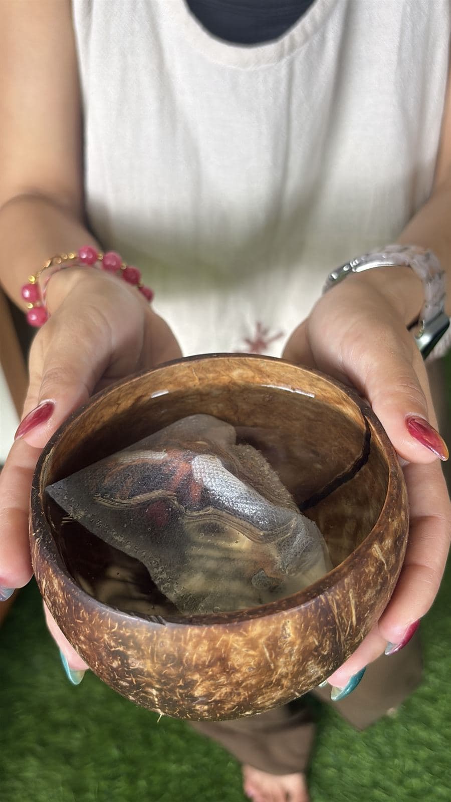 ココナッツのボウルの熱湯でティーバッグを蒸らすところ