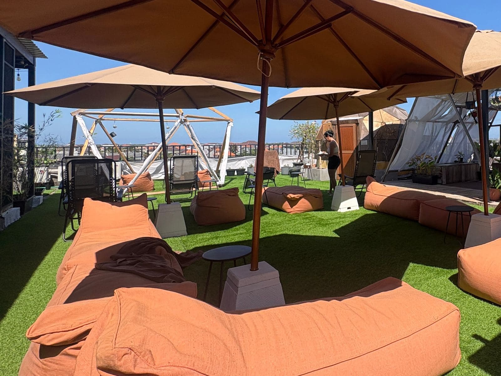 Beanbag loungers under umbrellas on the rooftop lawn