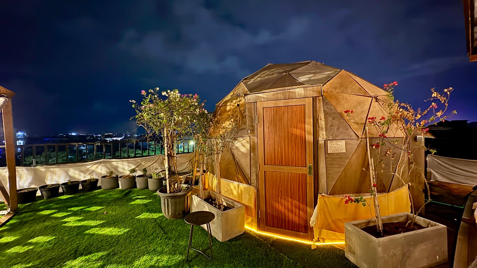 Geodesic dome sauna glowing at night on the Kuta rooftop lawn