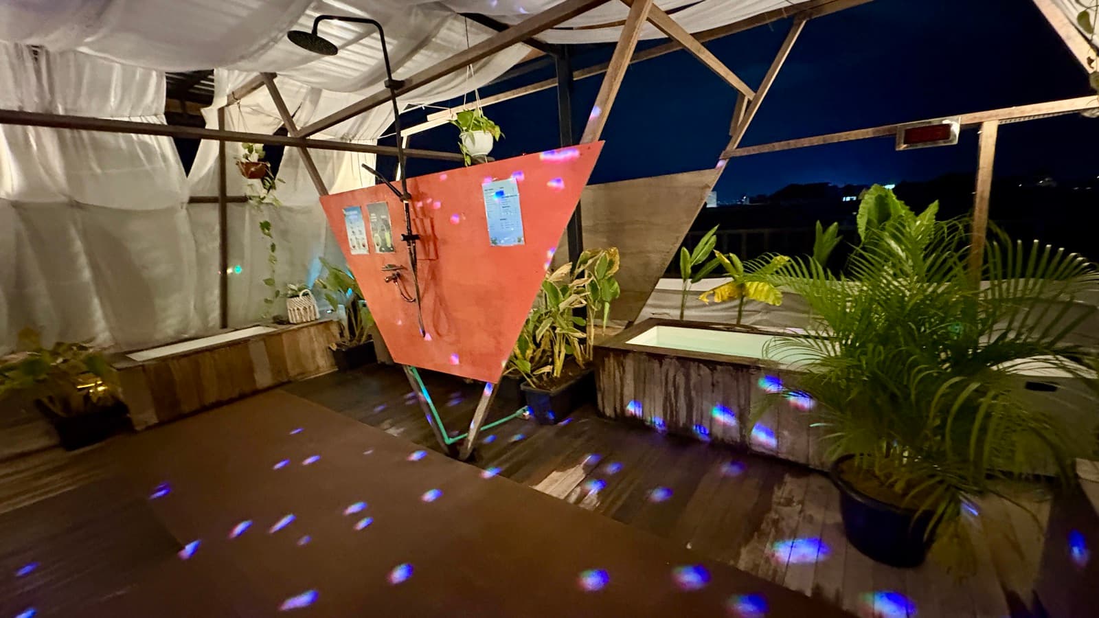 Mirror-ball light scattered across the night deck by the ice baths