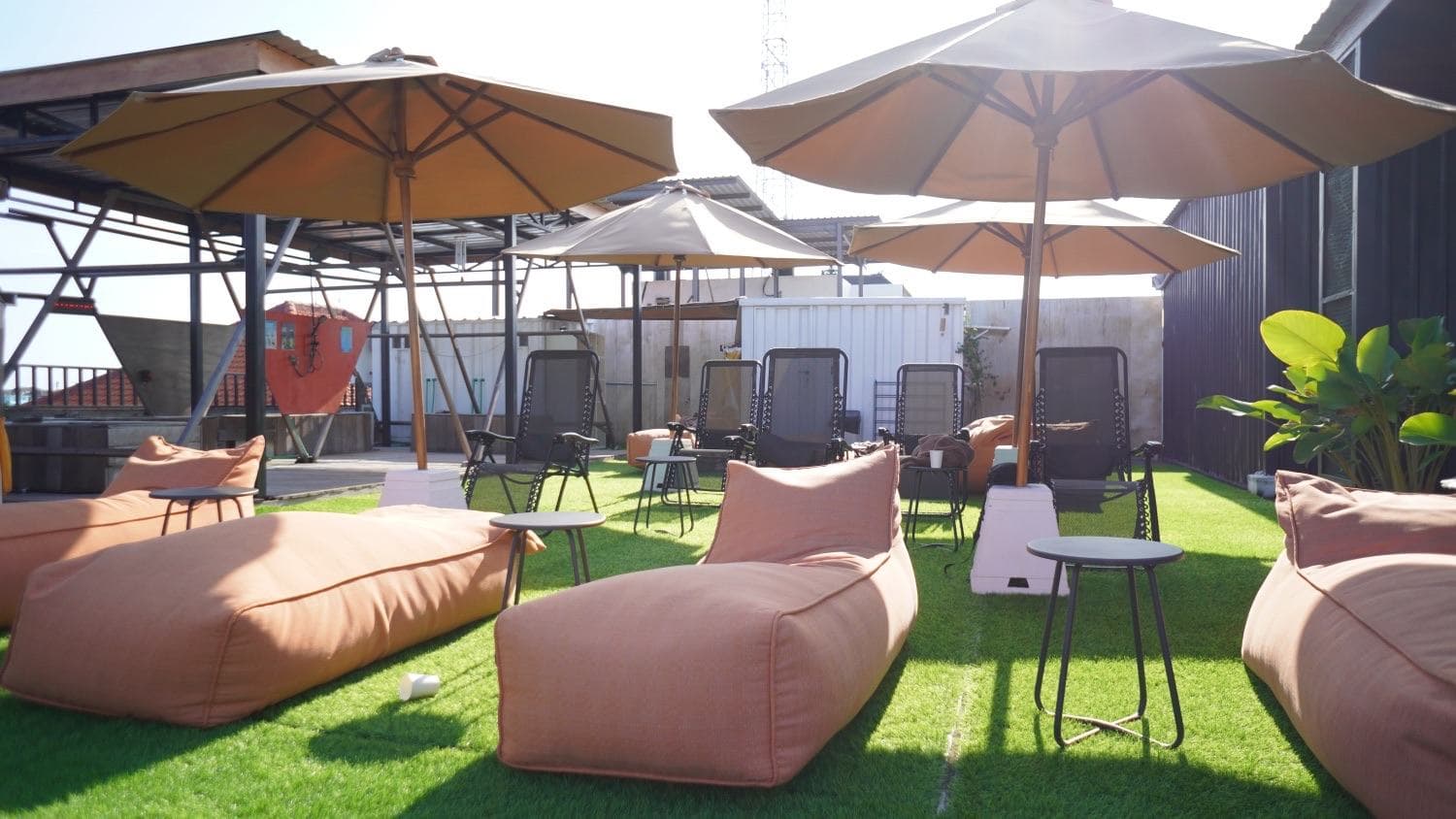 Overview of the rooftop with umbrellas, loungers and seating