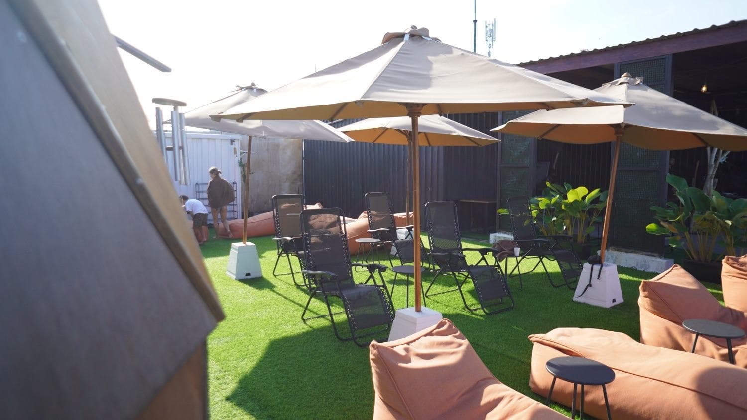 Bright rooftop with umbrellas and zero-gravity chairs in the breeze