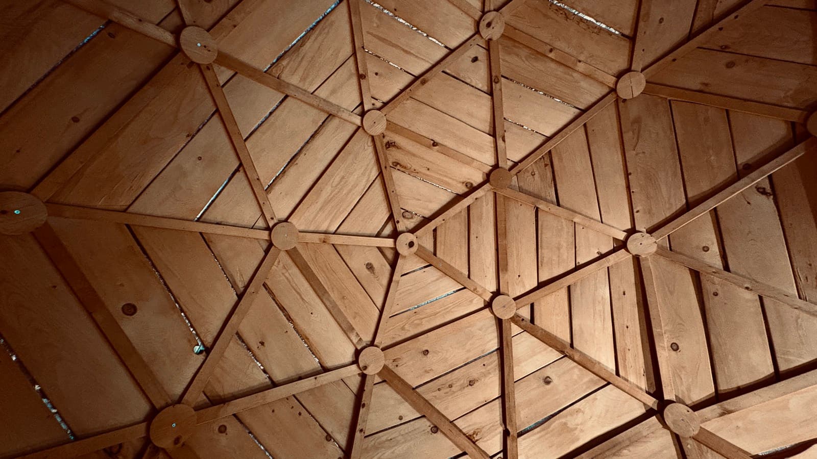 Geometric cedar ceiling of the geodesic dome, seen from the bench