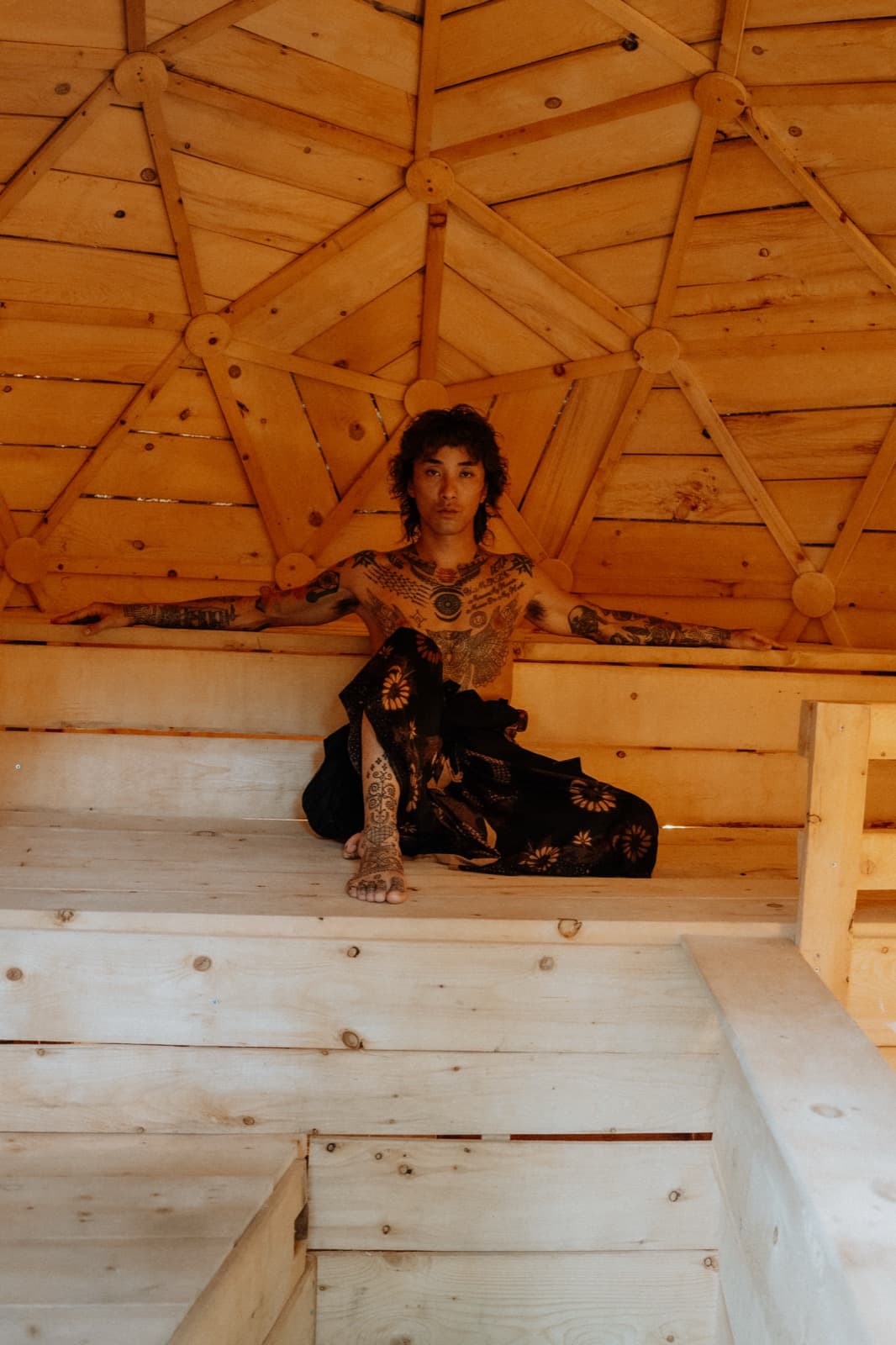 A guest seated on the dome bench, arms spread wide along the backrest