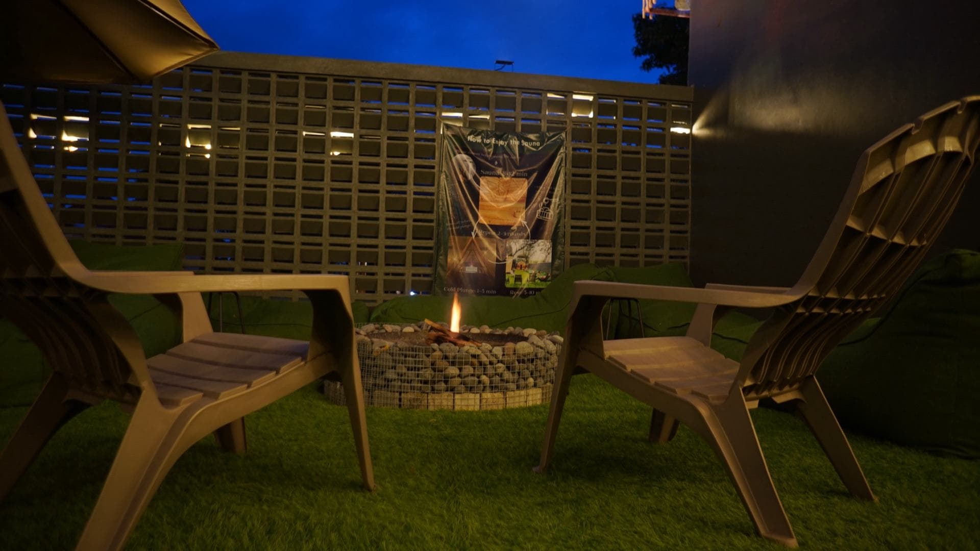 Fire pit burning between two chairs at night